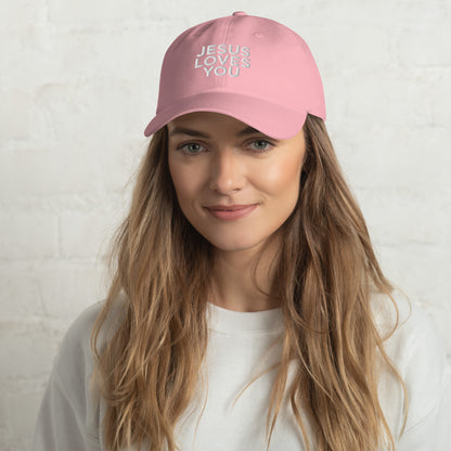 Person wearing a pink cap with 'JESUS LOVES YOU' text on a white background